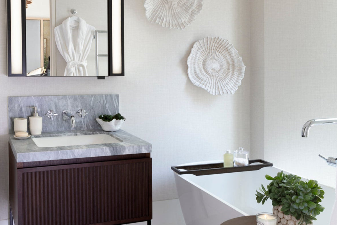Luxury bathroom with a sink, mirror, and bathtub.