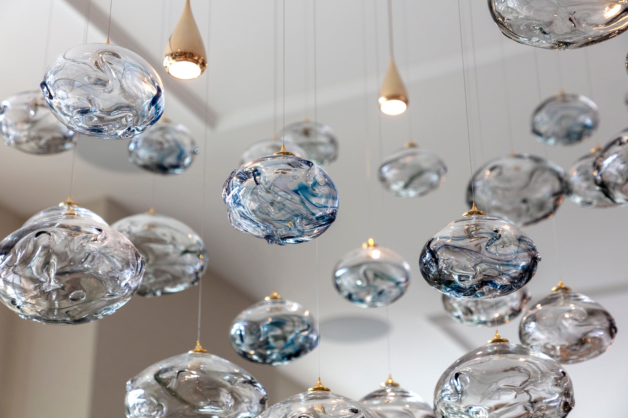 Glass pendant lighting within dining space of luxury high end apartment in Mayfair London, designed and installed by Nineteen Interiors
