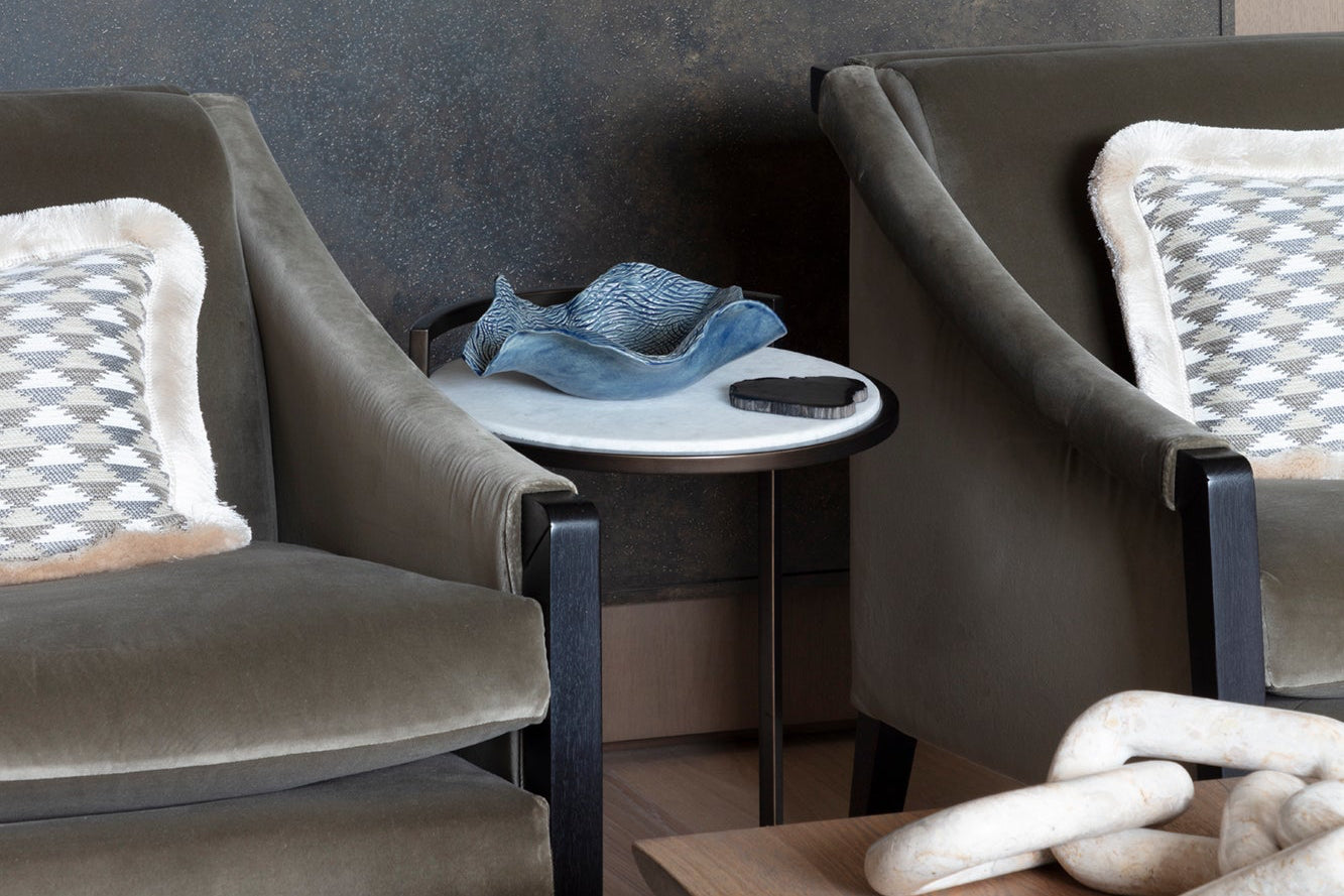 Bespoke green luxury armchairs with handmade patterned cushions and artwork, styled with accessories by Nineteen Interiors