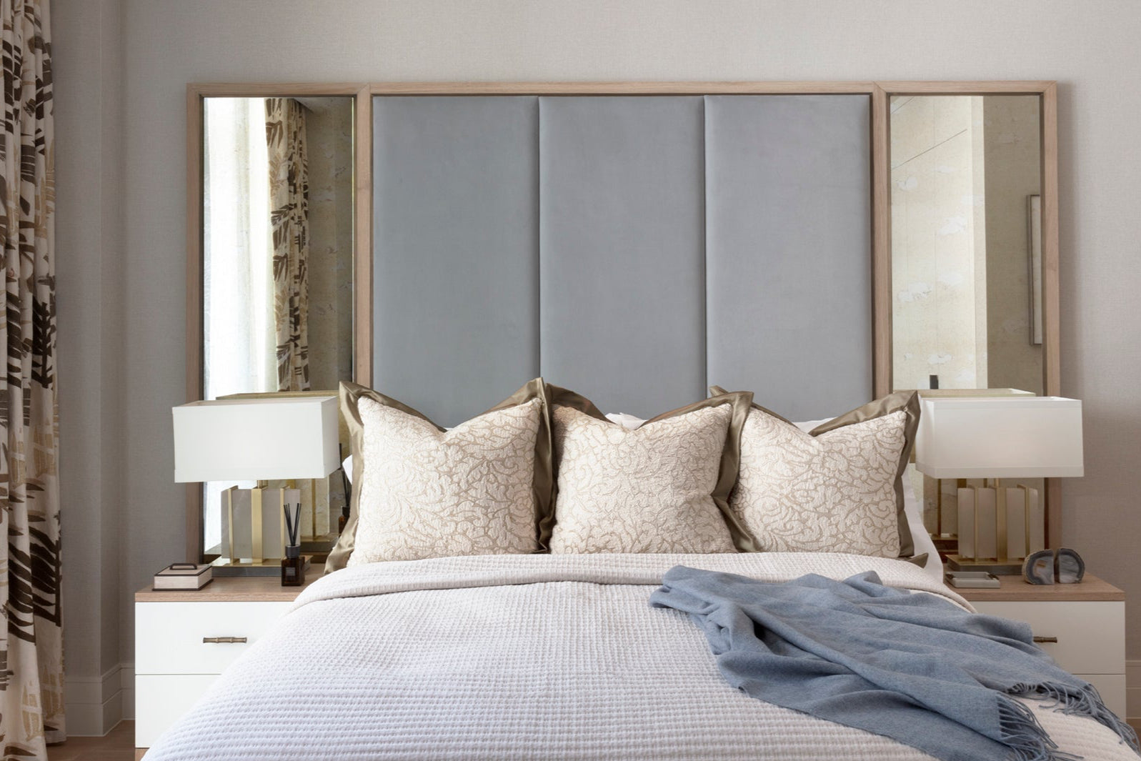Luxury guest bedroom with upholstered joinery headboard, mottled mirrors and bespoke side tables. Accessorised by Nineteen Interiors.