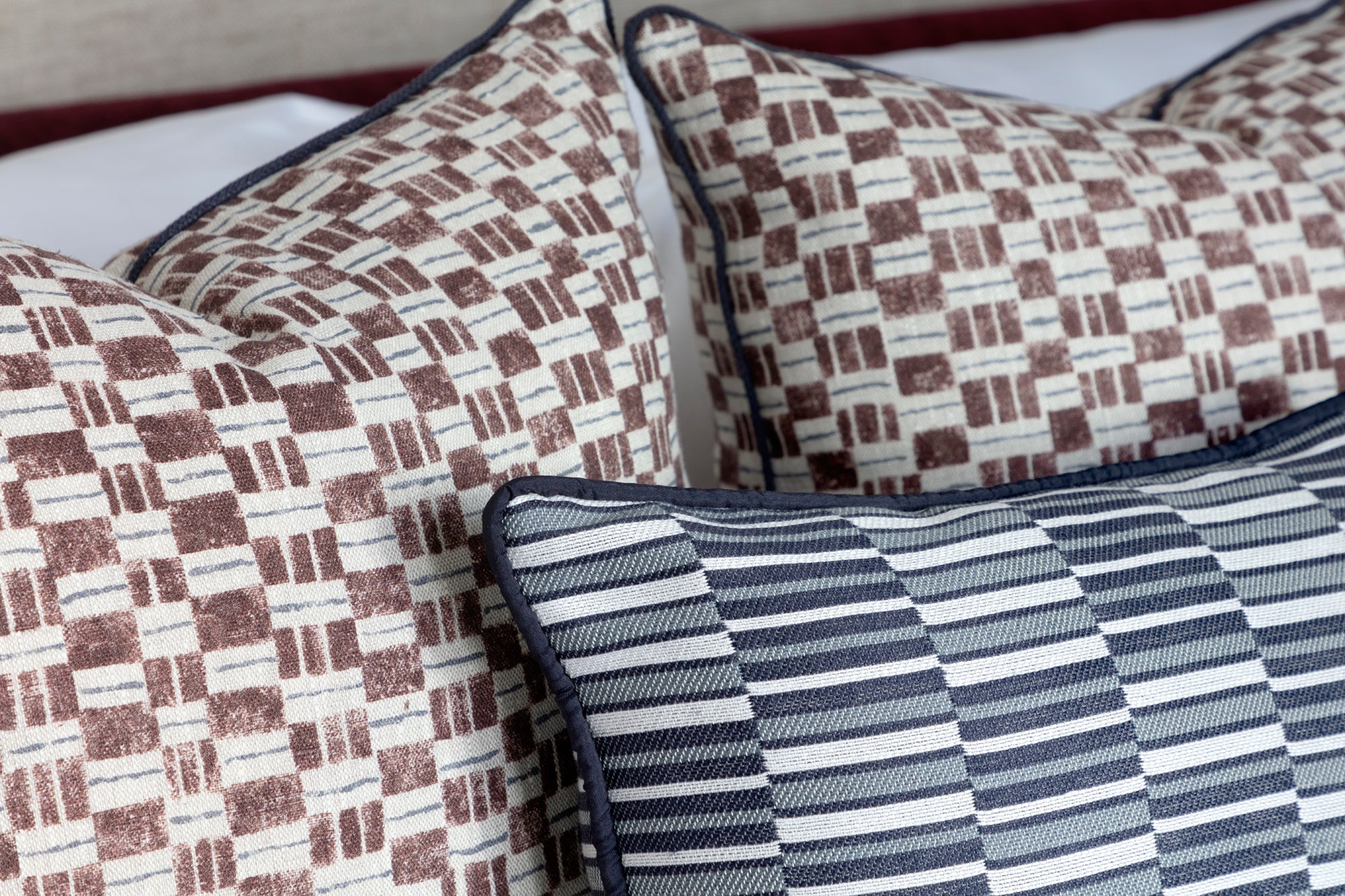 Patterned cushions on a bed with a focus on texture and design.