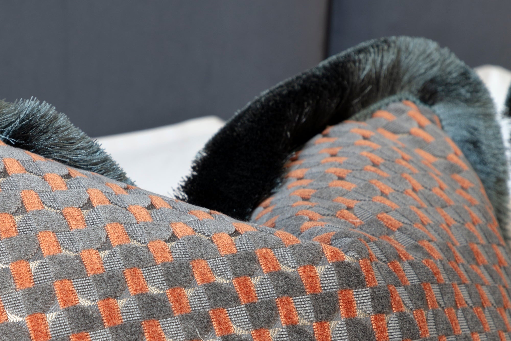 Close-up of a textured cushion fabric with orange and oil stained blue pattern