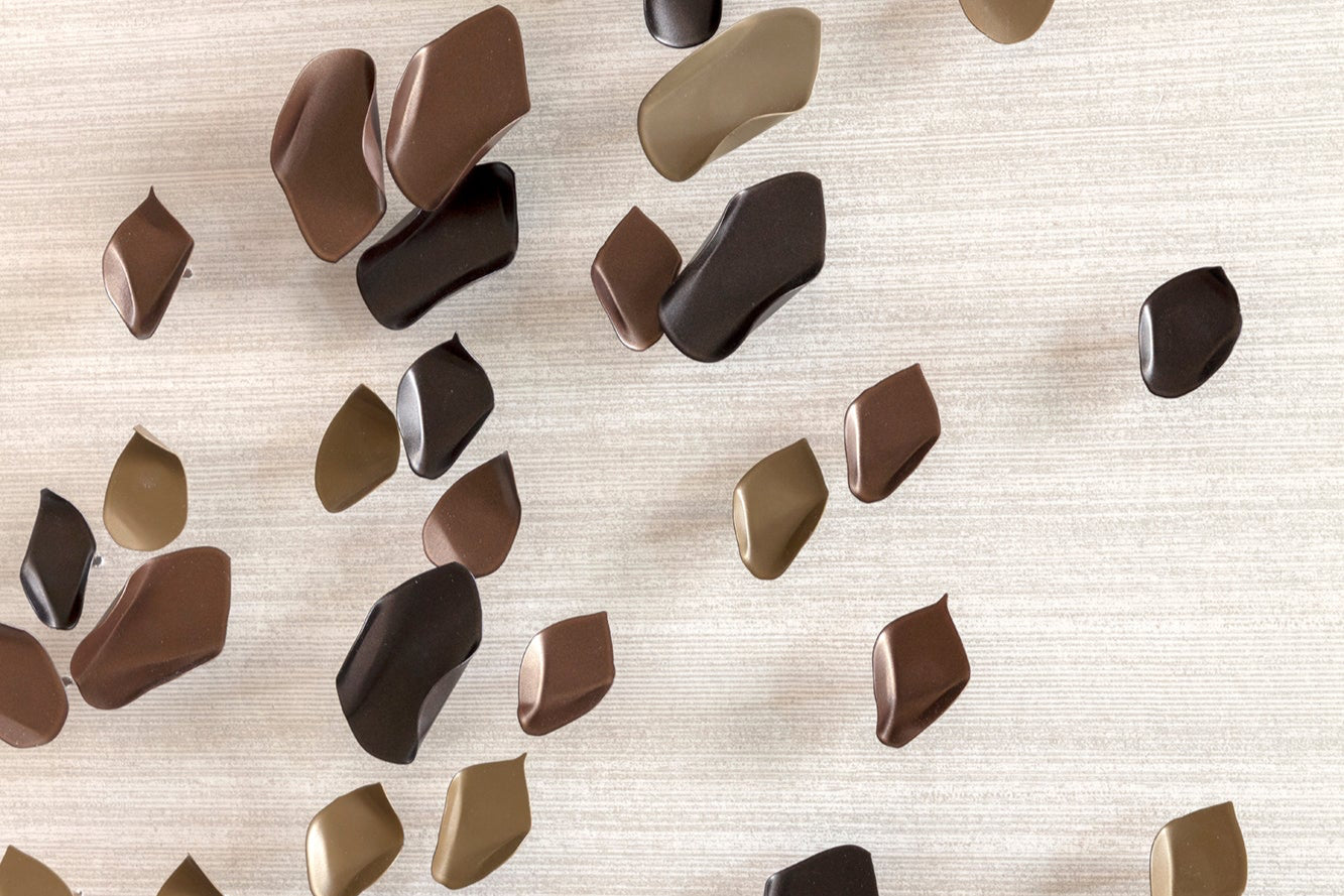 Combination of brown, chocolate and brass metal handmade art pieces installed on to a luxury wallpaper.