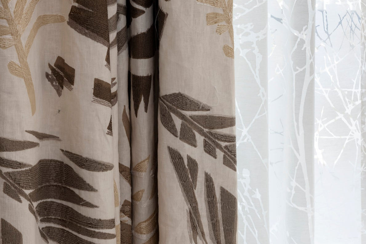 Close-up of patterned curtains with leaf design on a neutral background