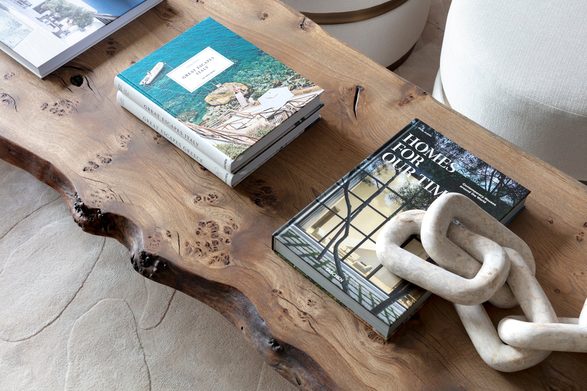 Luxury bespoke rugs, bespoke furniture, natural driftwood coffee table with display books and marble sculpture.