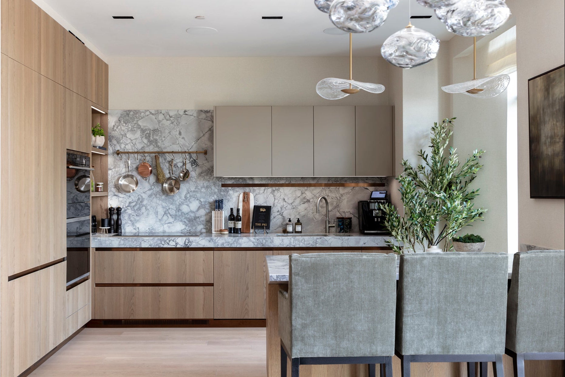 Modern kitchen with bespoke wooden cabinets, bespoke glass pendants and accessories by Nineteen Interiors.