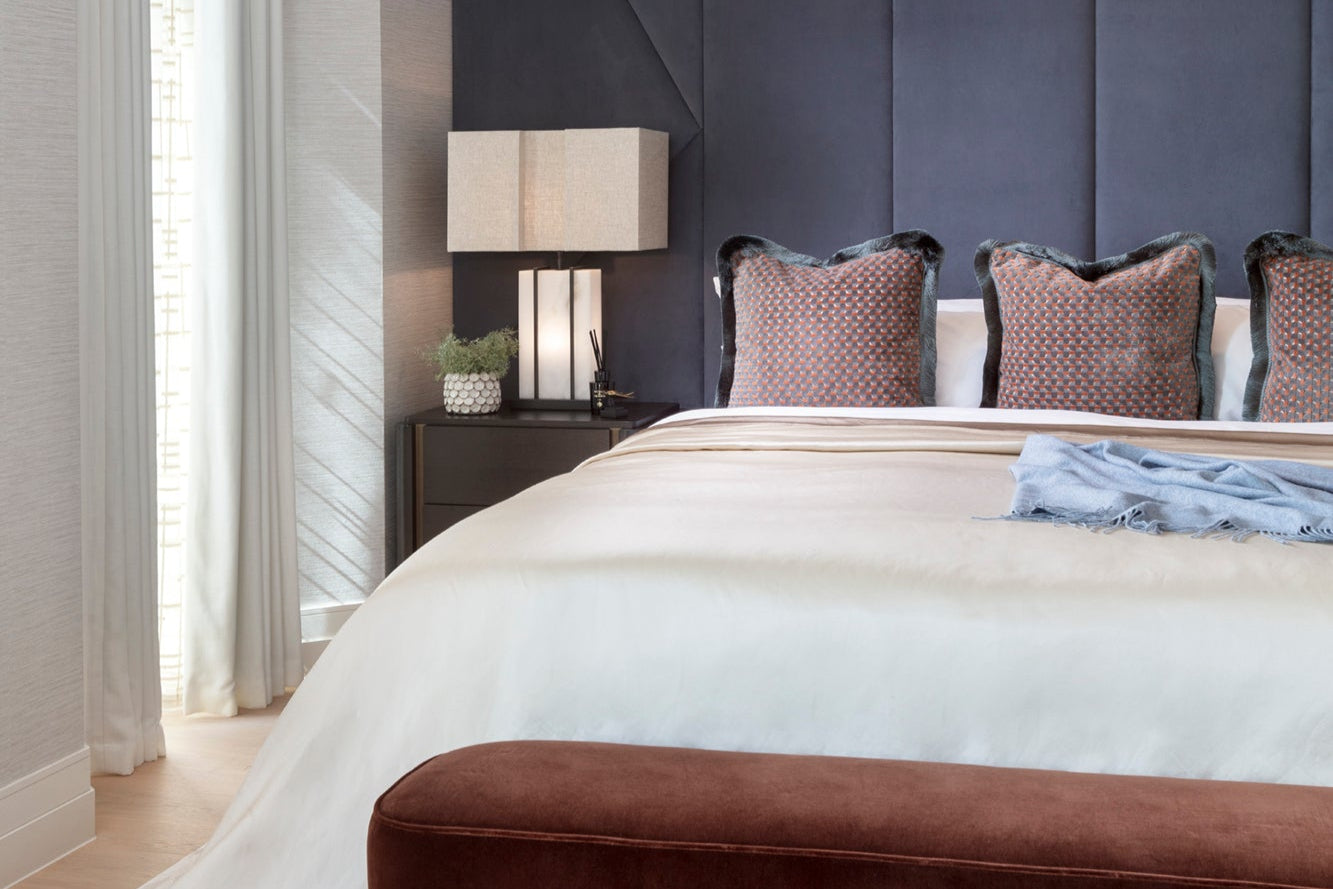 Modern bedroom with bespoke bedding, cushions and handmade voiles. Luxury throw and lighting. Styled by Nineteen Interiors.