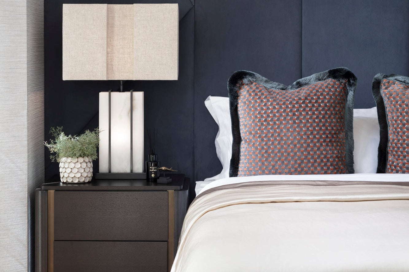 Modern luxury masculine bedroom with dark wood tones, handmade cushions and bedding. Accessories by Nineteen Interiors.