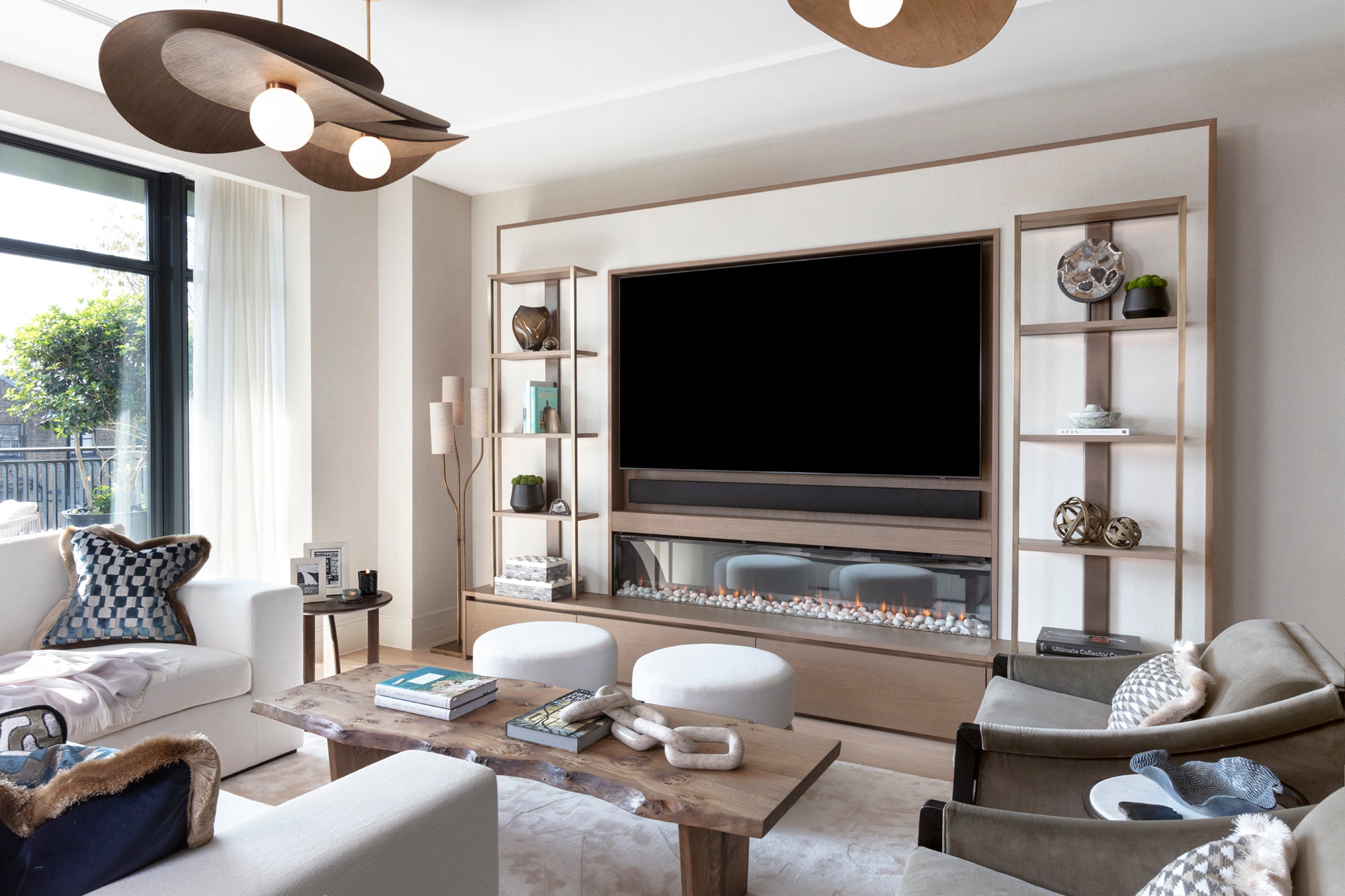 Entertainment space with television, surround sound, ceiling speakers, fireplace, games console, including luxury bar and wine fridges all designed and styled by Nineteen Interiors