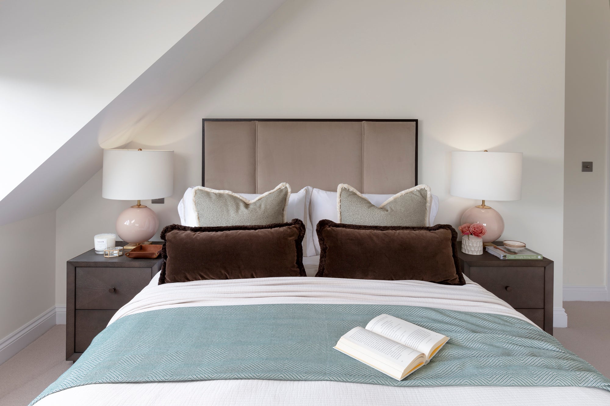 Bespoke-made headboard with cushions, handblown glass lamps, luxury bedside tables, and a stylish bedspread and bedding. The design includes a bolster cushion, creating a luxurious and cosy bedroom environment with refined elegance and attention to detail