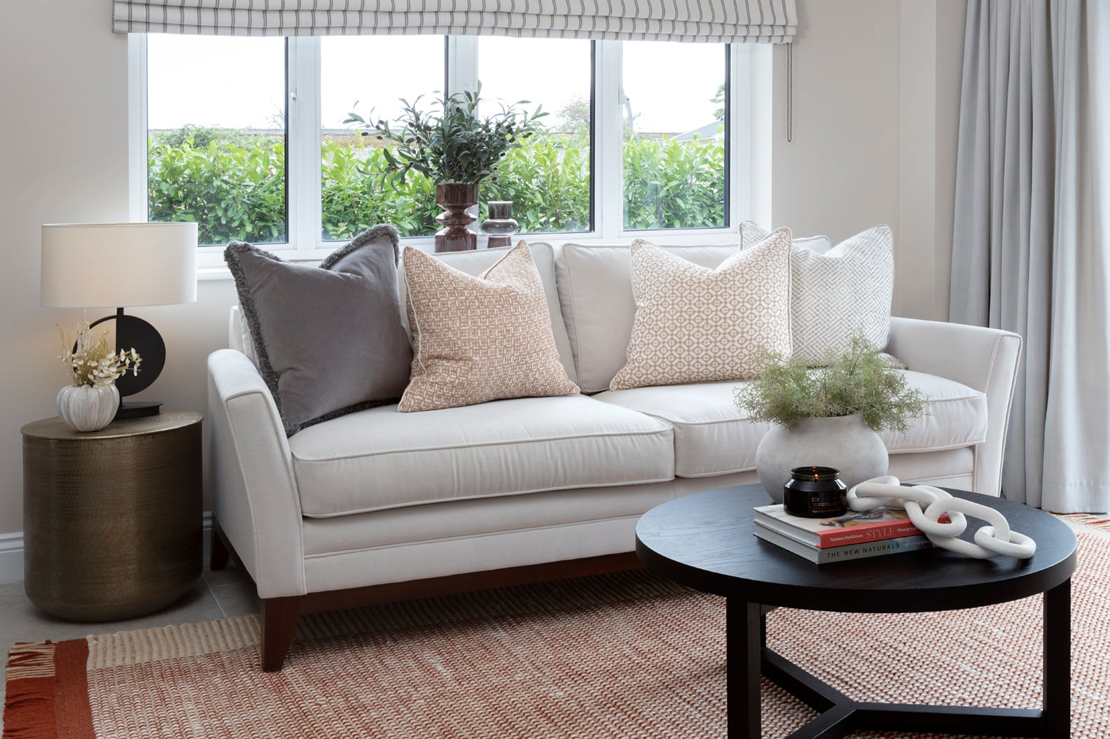 Family living area in Buckinghamshire featuring bespoke cushions, rustic charm, and metal design elements. The space blends cosy, comfortable furnishings with industrial touches, creating a stylish and inviting atmosphere perfect for family gatherings
