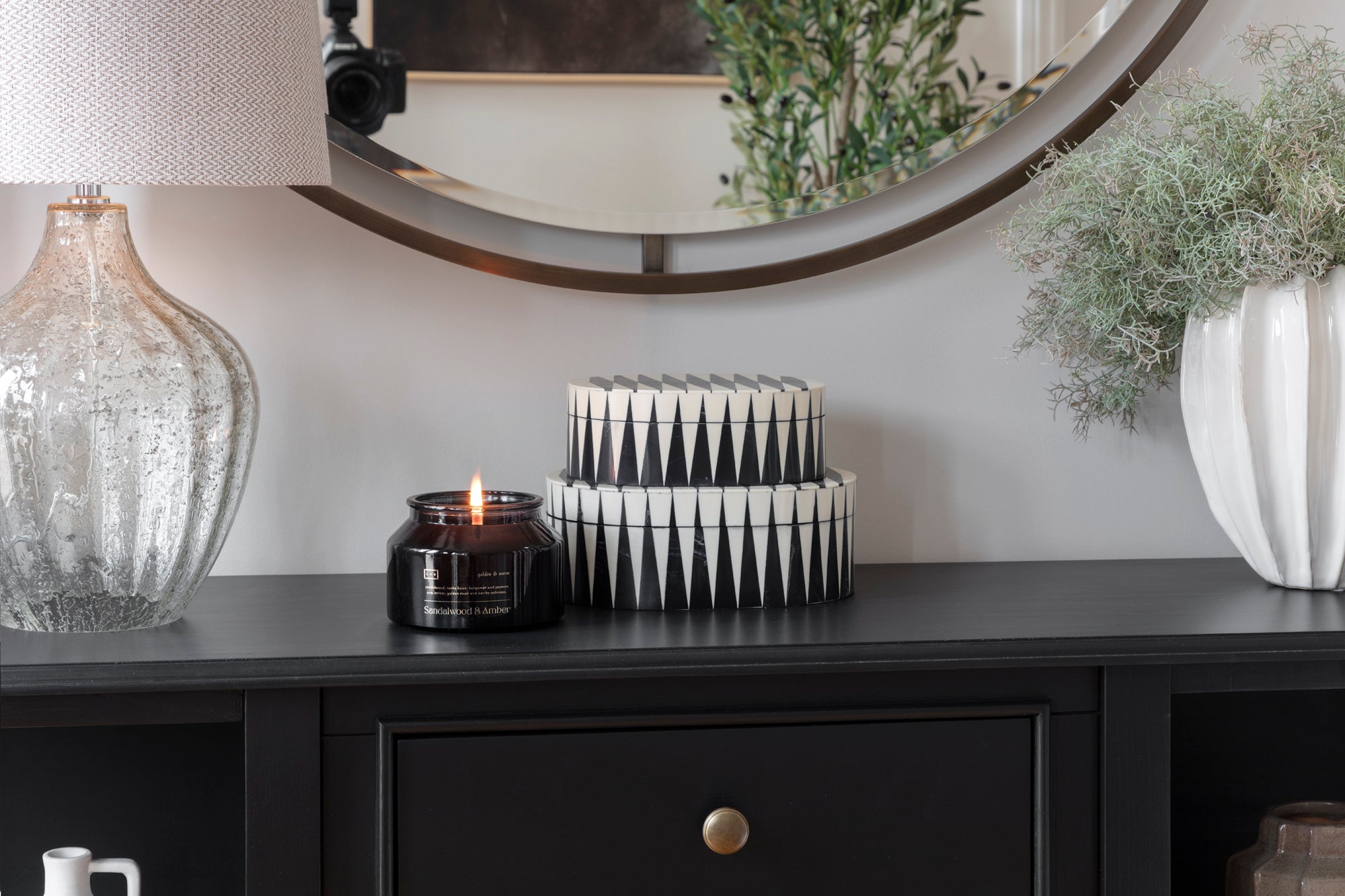 Fully accessorised design in a family countryside hallway featuring handmade candles, a handblown vase, mirrors, and a timber sideboard. The design combines natural materials with thoughtful decoration, creating a cosy and welcoming atmosphere with a rustic charm